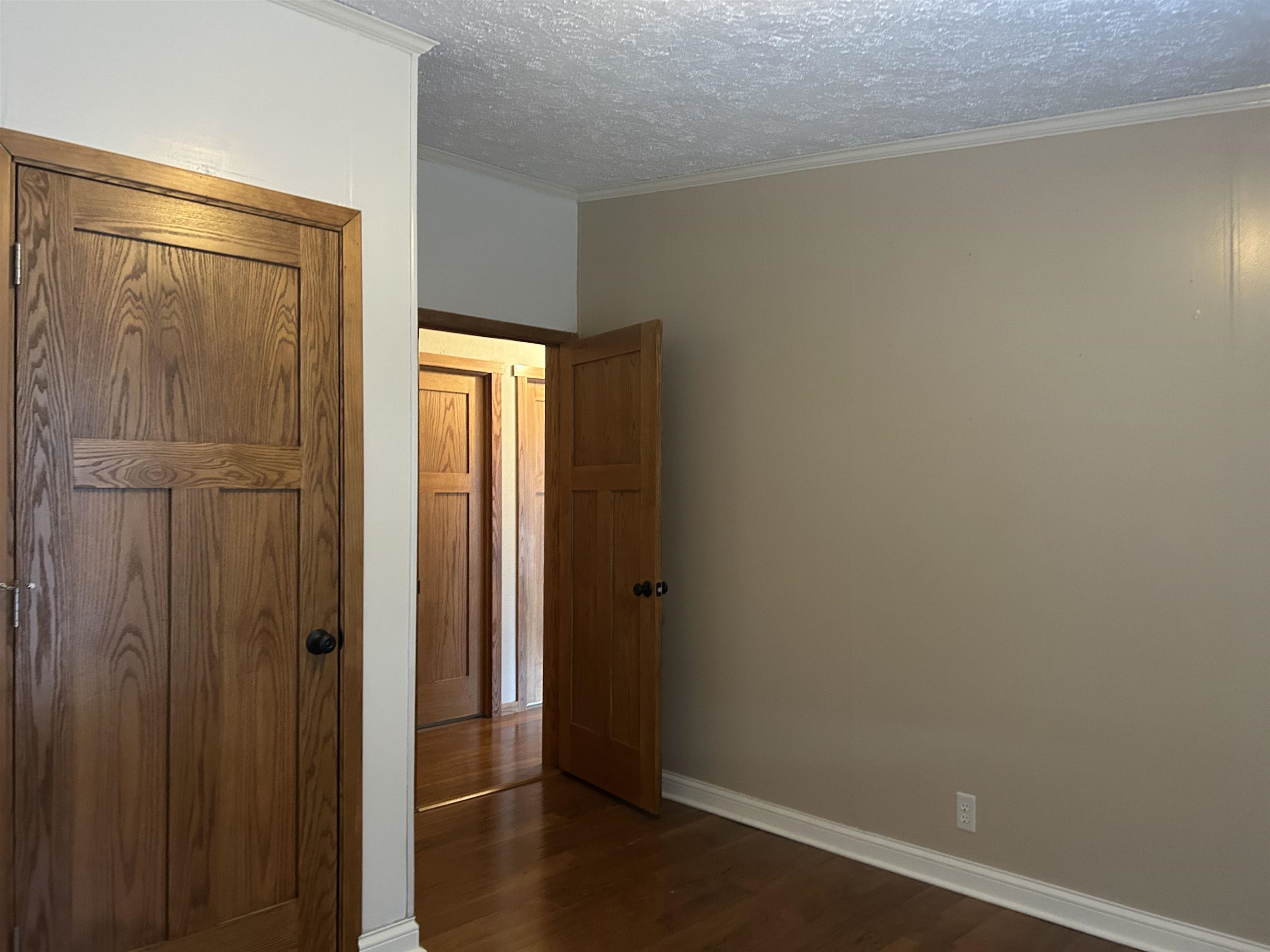 1302 Old North Shore Road Duluth, MN 55804 - Photo 64 of 75 Unfurnished bedroom with a textured ceiling, ornamental molding, and dark wood-type flooring