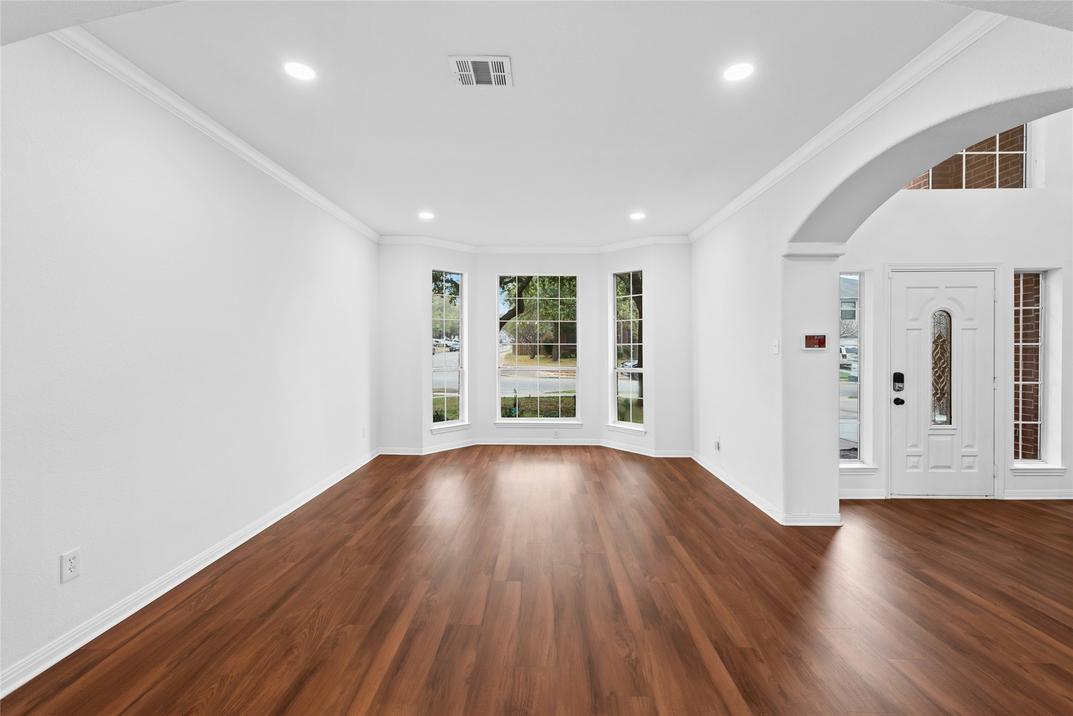 813 Caribou Ridge Trail Pflugerville, TX 78660 - Photo 5 of 39 Elegant foyer showcasing arched walkways, ornamental molding, recessed lighting, and rich wood-style flooring that adds warmth and architectural character.