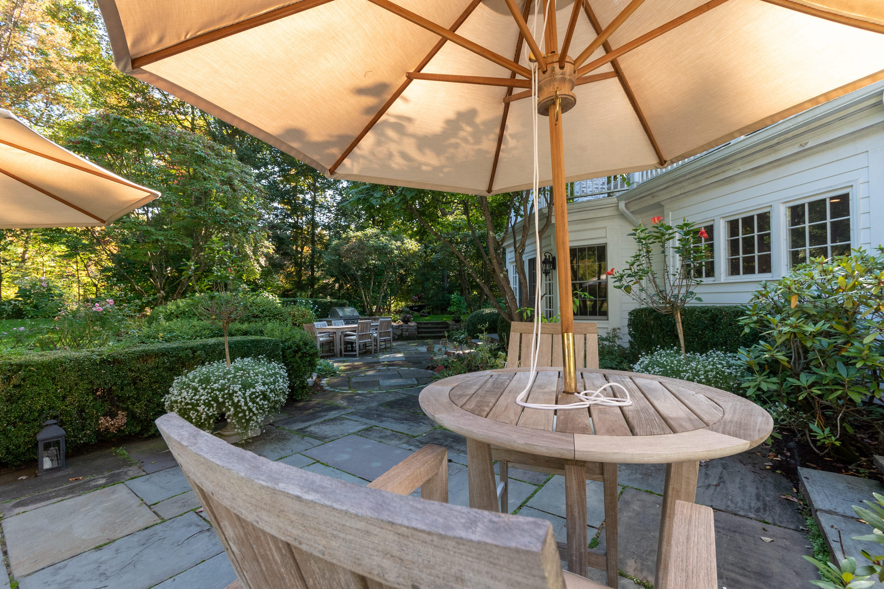 16 Shagbark Road Darien, CT 06820 - Photo 46 of 55 a view of a patio with table and chairs potted plants with wooden floor and fence