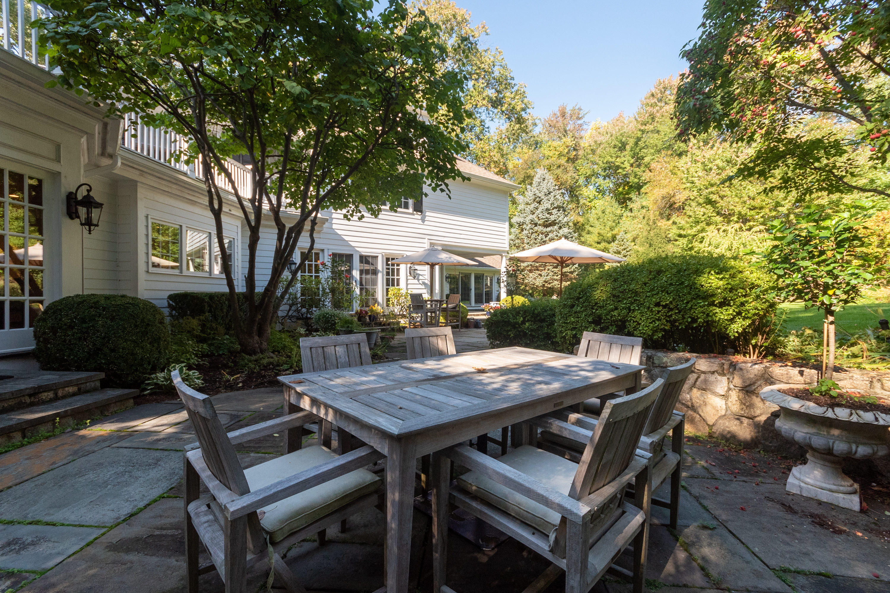 16 Shagbark Road Darien, CT 06820 - Photo 47 of 55 a view of a patio with table and chairs and potted plants with large tree