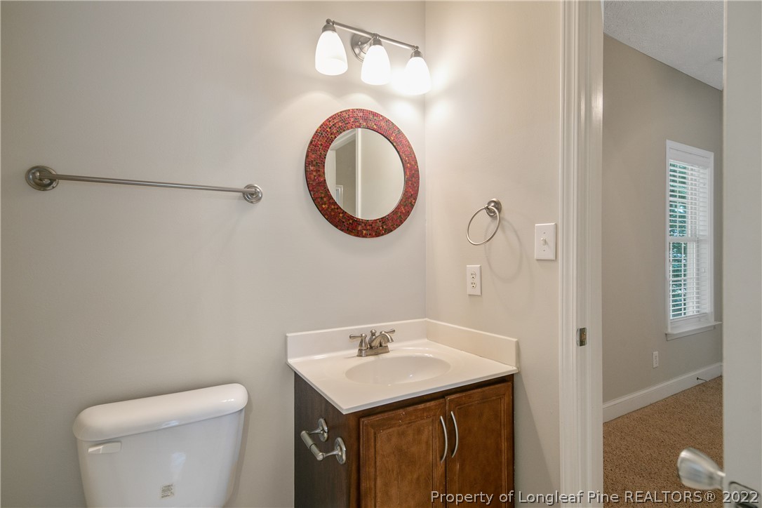 95 Crystal Point Sanford, NC 27332 - Photo 21 of 33 a bathroom with a toilet a sink and a mirror