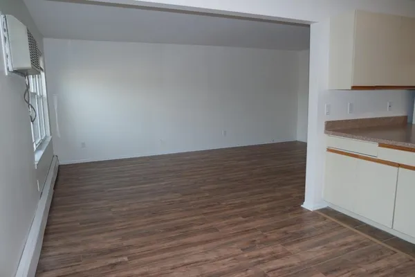 a view of an empty room with wooden floor