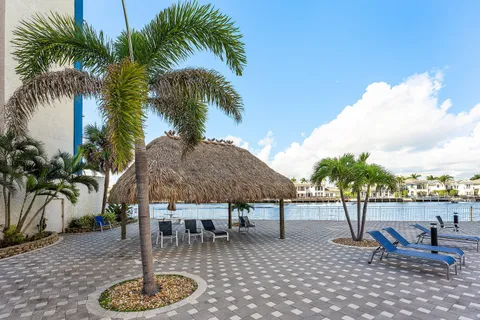 a swimming pool with outdoor seating and a palm tree