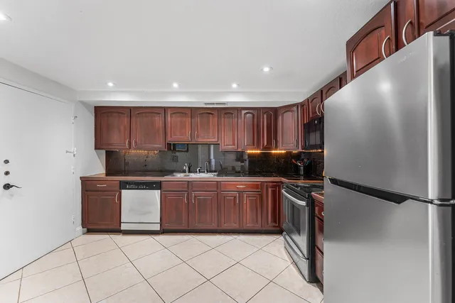 a kitchen with stainless steel appliances granite countertop a refrigerator and a sink