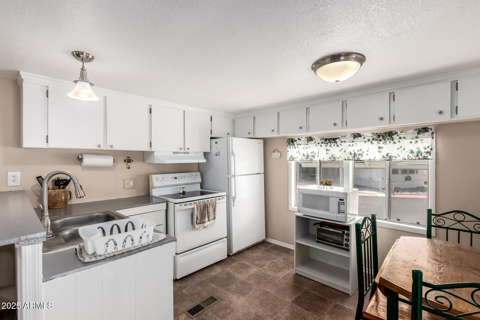 800 West Apache Trail, Unit 24 Apache Junction, AZ 85120 - Photo 12 of 27 a kitchen with white cabinets and stainless steel appliances