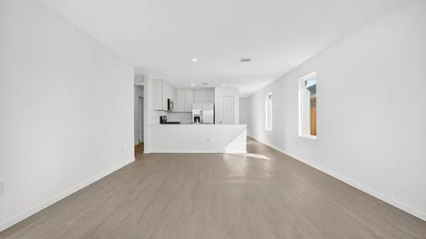 a view of a kitchen with wooden floor and windows