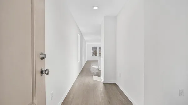 a view of a hallway with wooden floor