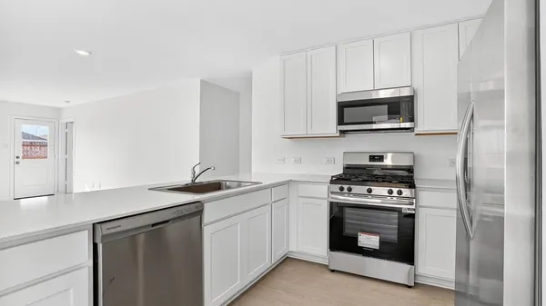 a kitchen with stainless steel appliances granite countertop a sink a stove and microwave