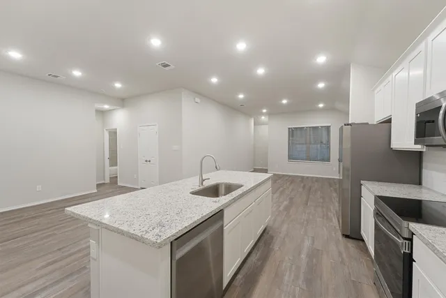 a kitchen with stainless steel appliances granite countertop a sink and a refrigerator