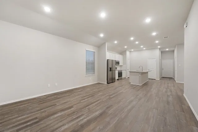 a view of an empty room with wooden floor