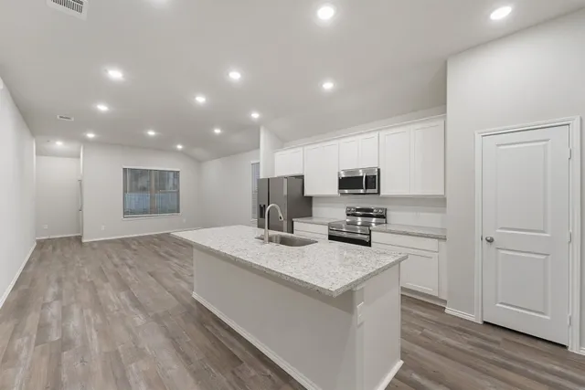 a kitchen with stainless steel appliances granite countertop a sink stove and refrigerator