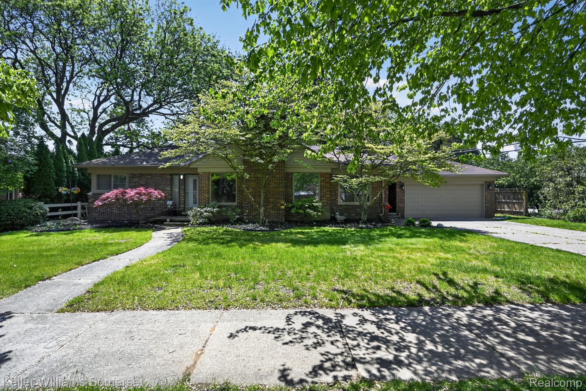 1681 Oxford Road Grosse Pointe, MI 48236 - Photo 1 of 25 View of front of house featuring a front lawn, a garage, brick siding, and concrete driveway
