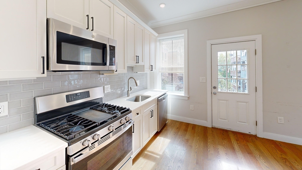 191 Porter Street, Unit 4 Boston, MA 02128 - Photo 1 of 8 a kitchen with a stove and a microwave