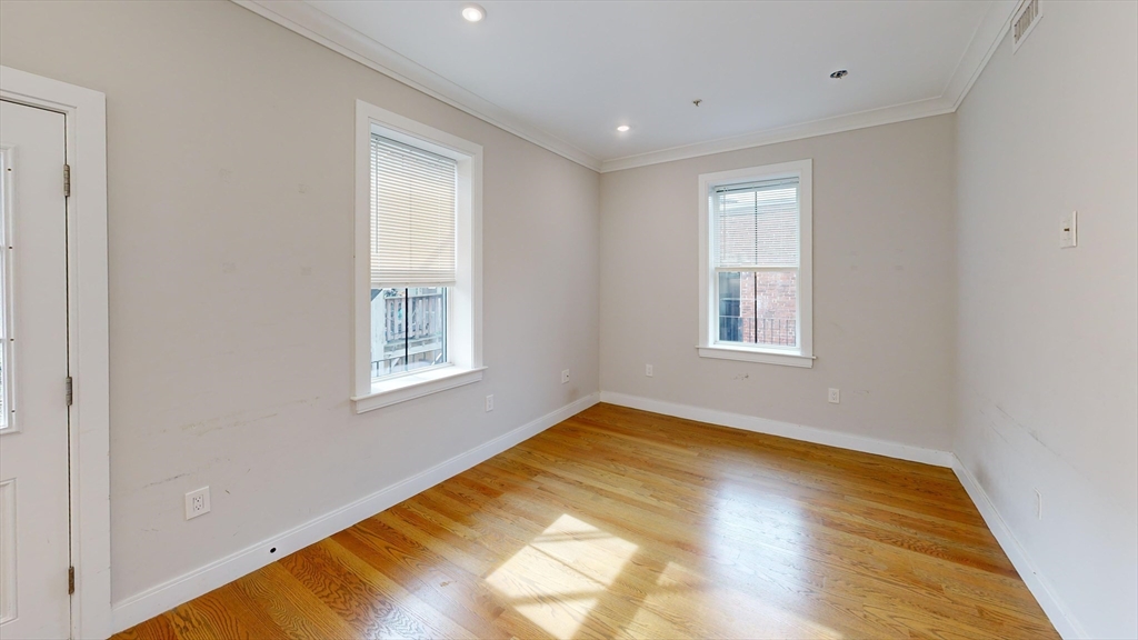 191 Porter Street, Unit 4 Boston, MA 02128 - Photo 5 of 8 a view of an empty room with wooden floor and a window