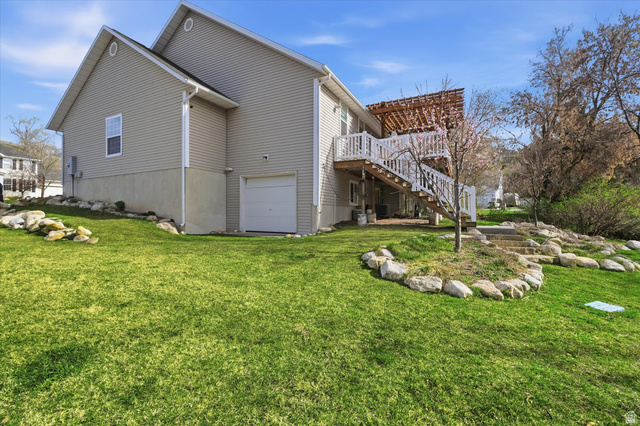 353 Robin Street Smithfield, UT 84335 - Photo 51 of 70 View of home's exterior featuring a garage, a wooden deck, and a yard