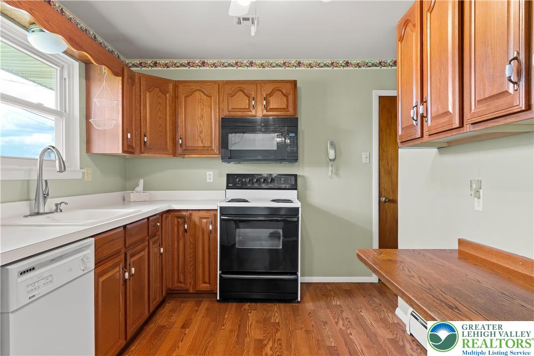2141 Aster Road Lower Macungie Township, PA 18062 - Photo 33 of 62 a kitchen with stainless steel appliances granite countertop a stove a sink and a microwave