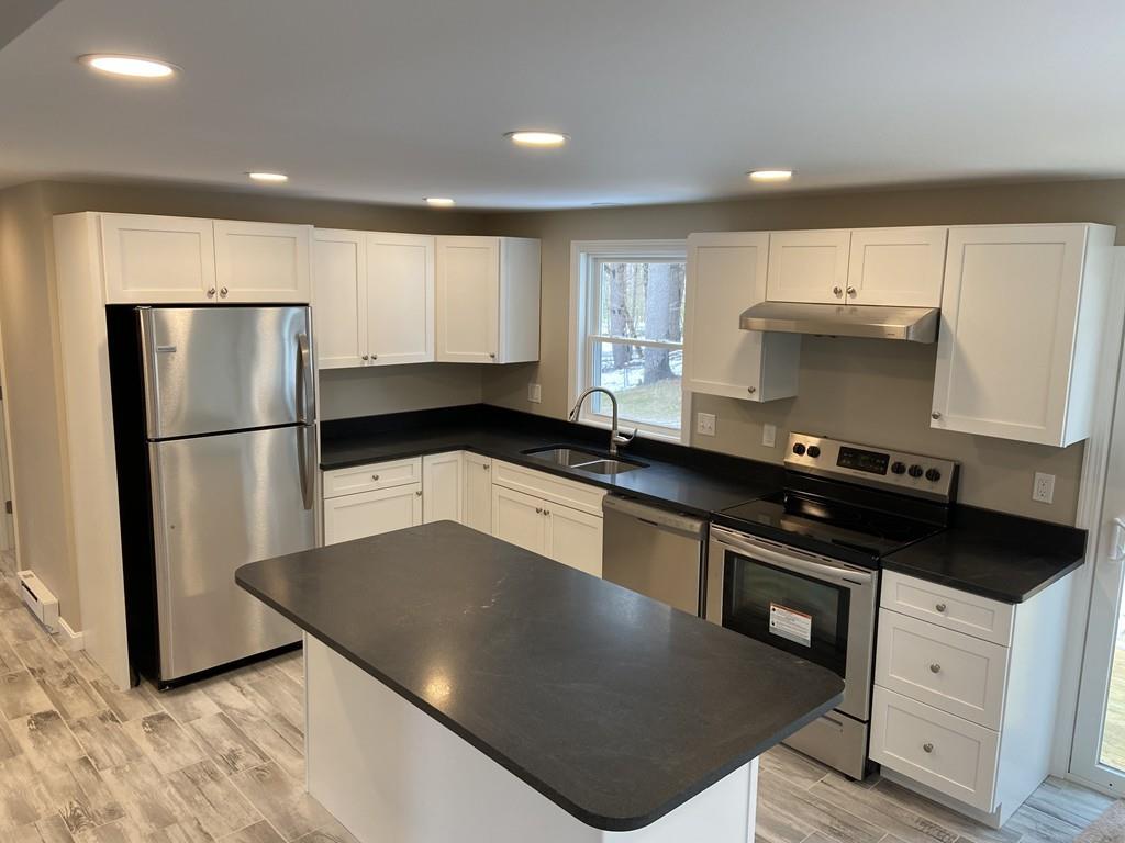 77 May Brook Road Holland, MA 01521 - Photo 6 of 23 a kitchen with granite countertop a refrigerator a stove a sink a counter space and cabinets