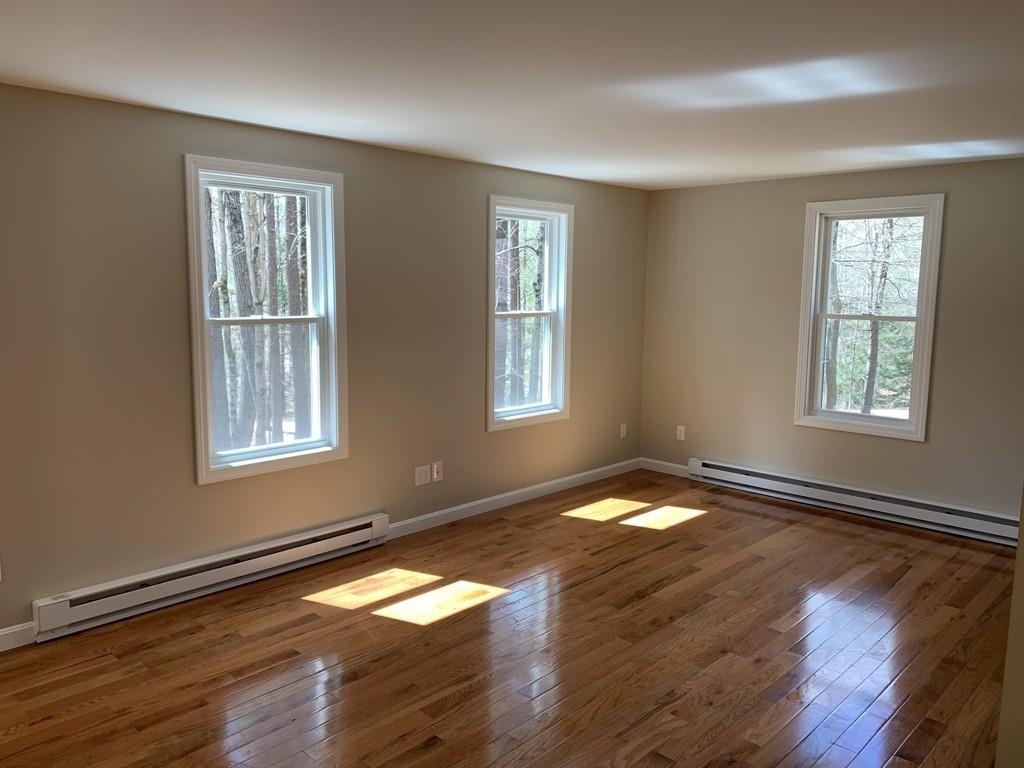 77 May Brook Road Holland, MA 01521 - Photo 9 of 23 a view of empty room with wooden floor and fan