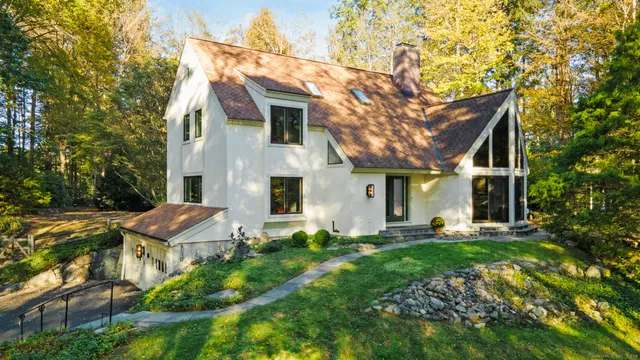 a front view of house with yard and trees in the background