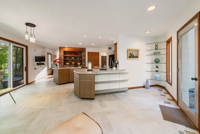 a view of living room kitchen with stainless steel appliances kitchen island granite countertop a refrigerator and stove top oven