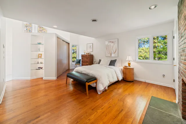 a spacious bedroom with a bed and wooden floor