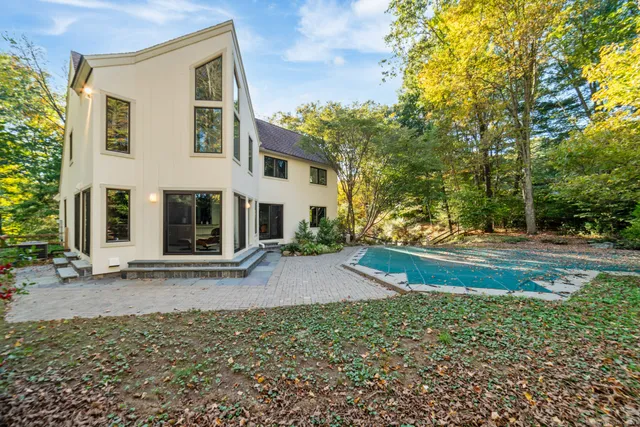 a view of a house with backyard and trees
