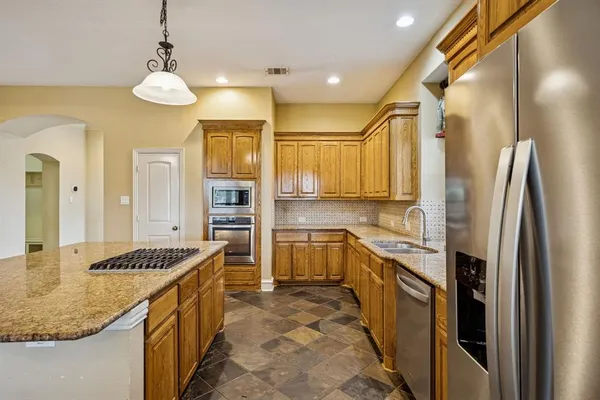a kitchen with stainless steel appliances granite countertop a sink and cabinets