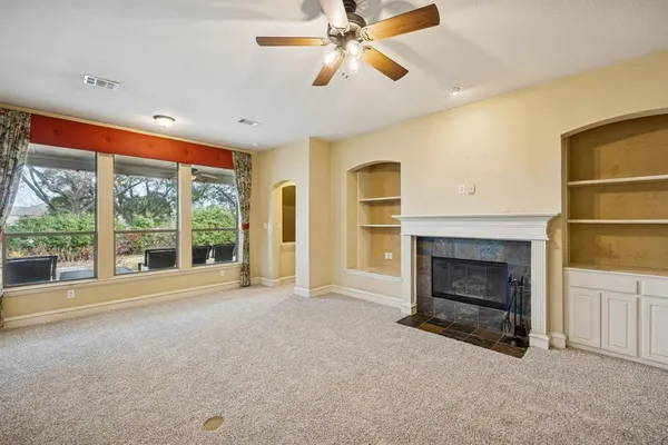 a view of an empty room with a fireplace and a window