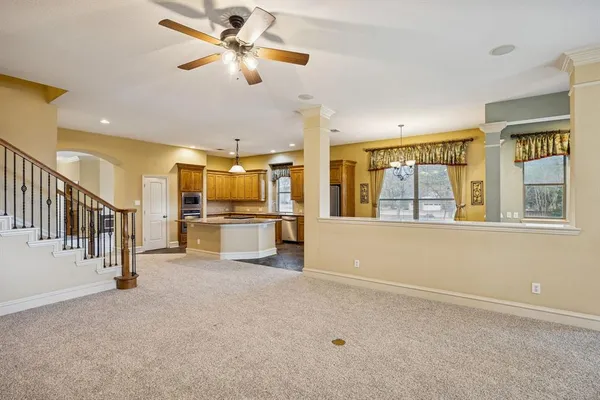 a view of a livingroom with furniture a ceiling fan and window