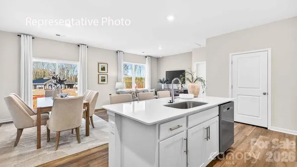 a view of a kitchen area with furniture and wooden floor