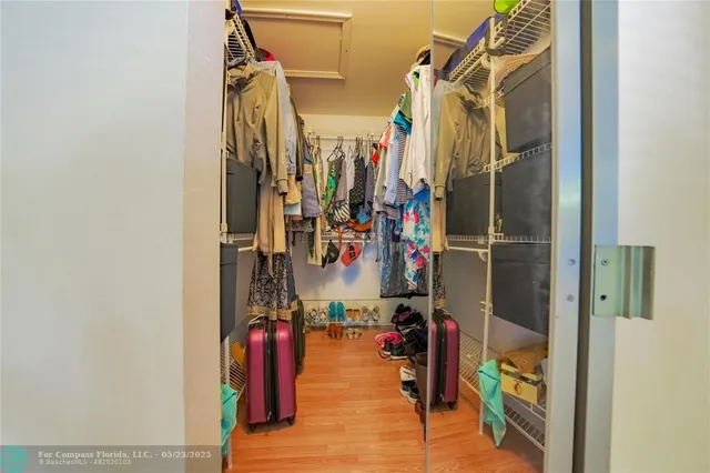 a view of walk in closet with clothes and shoes