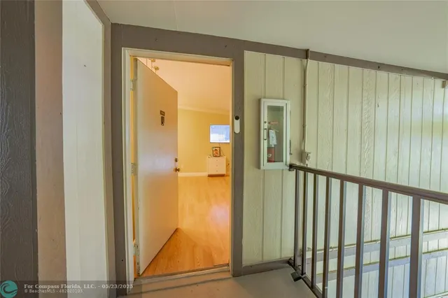 a view of a hallway with wooden floor and a door