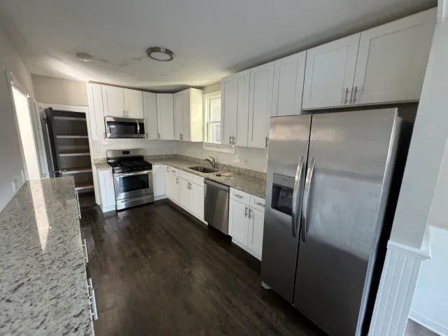a kitchen with stainless steel appliances a refrigerator sink and microwave