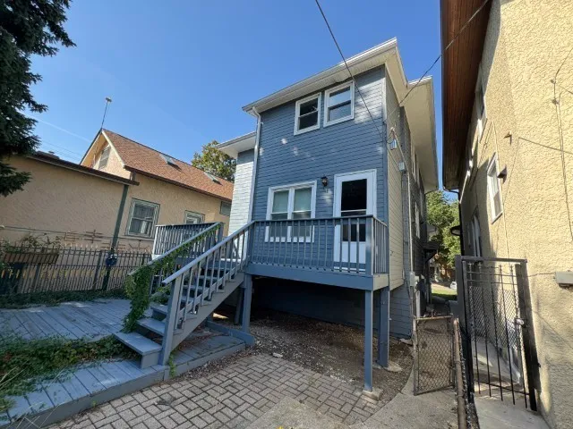 a view of a house with a wooden deck and furniture