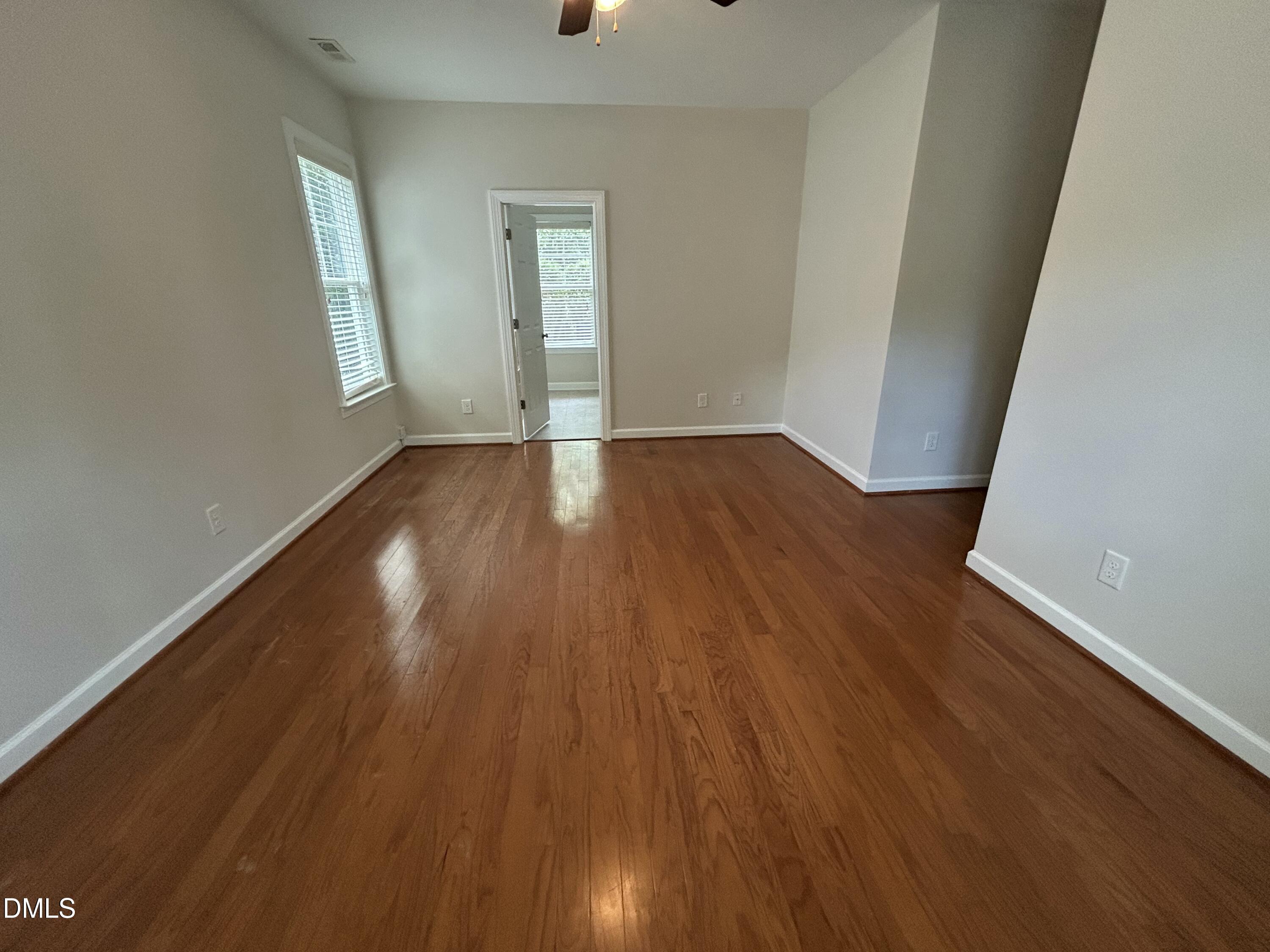 3837 Cumberland Pond Road Raleigh, NC 27606 - Photo 15 of 33 an empty room with wooden floor and windows