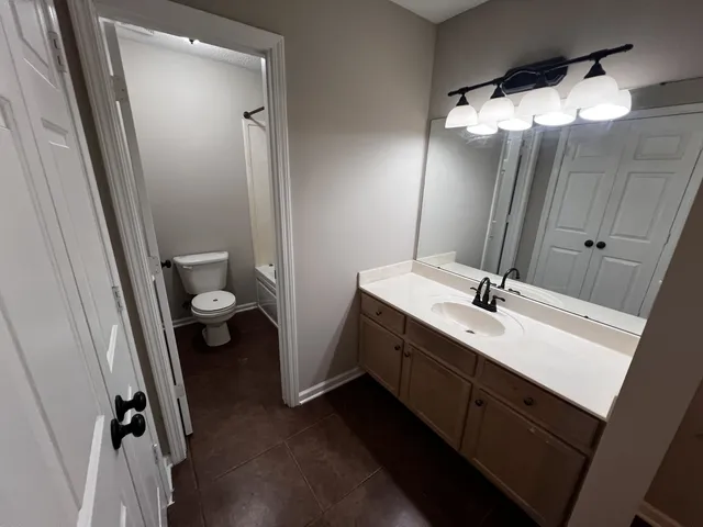 a bathroom with a double vanity sink toilet and shower