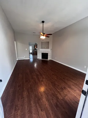 a view of a livingroom with wooden floor a fireplace and window