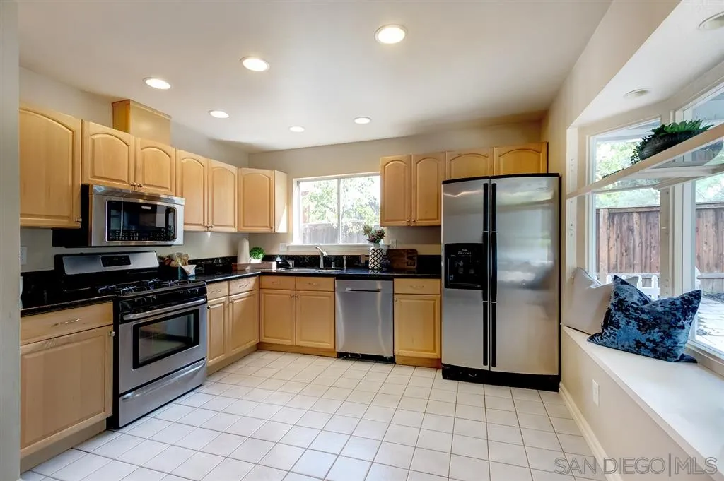 13856 Olive Grove Place Poway, CA 92064 - Photo 9 of 25 a kitchen with granite countertop a refrigerator and a sink