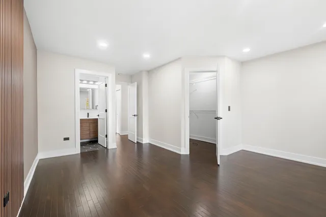 a view of a big room with wooden floor and windows