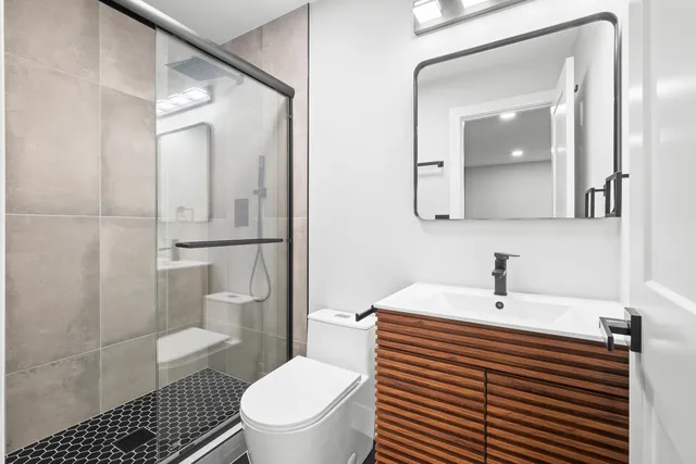 a bathroom with a sink a toilet and shower