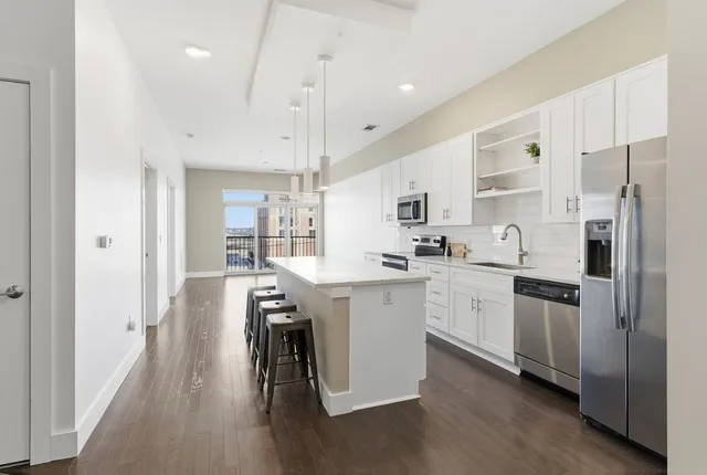 a kitchen with white cabinets and stainless steel appliances
