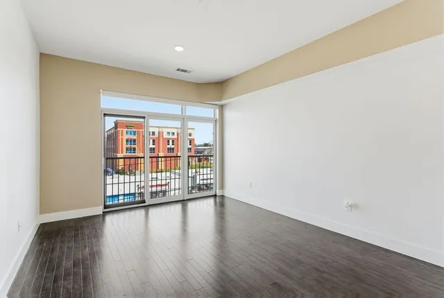 a view of an empty room with wooden floor
