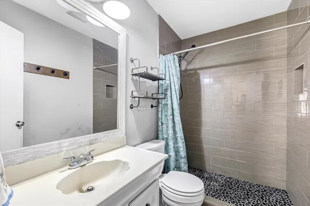 a bathroom with a sink a toilet and shower