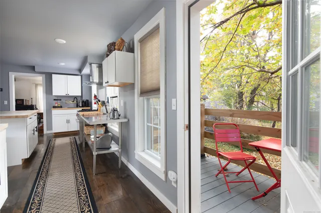 a view of a dining room with furniture a rug and wooden floor