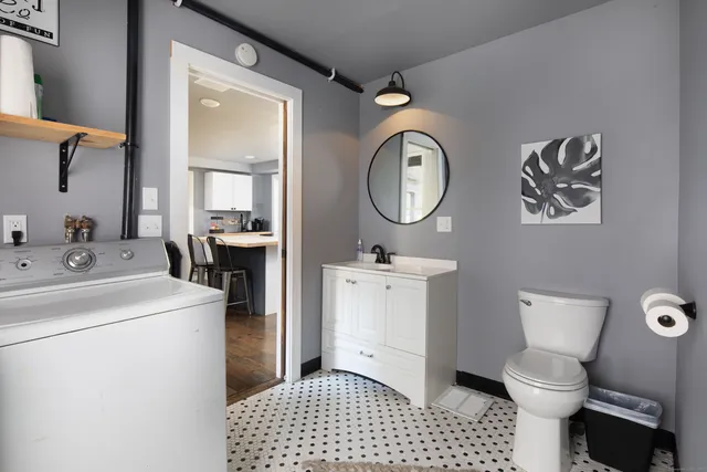 a bathroom with a toilet a sink and a mirror