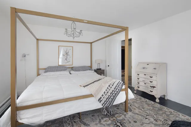 a bedroom with a bed a dresser and decor