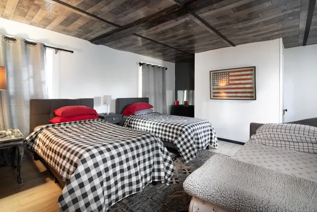 a bedroom with three beds and a window