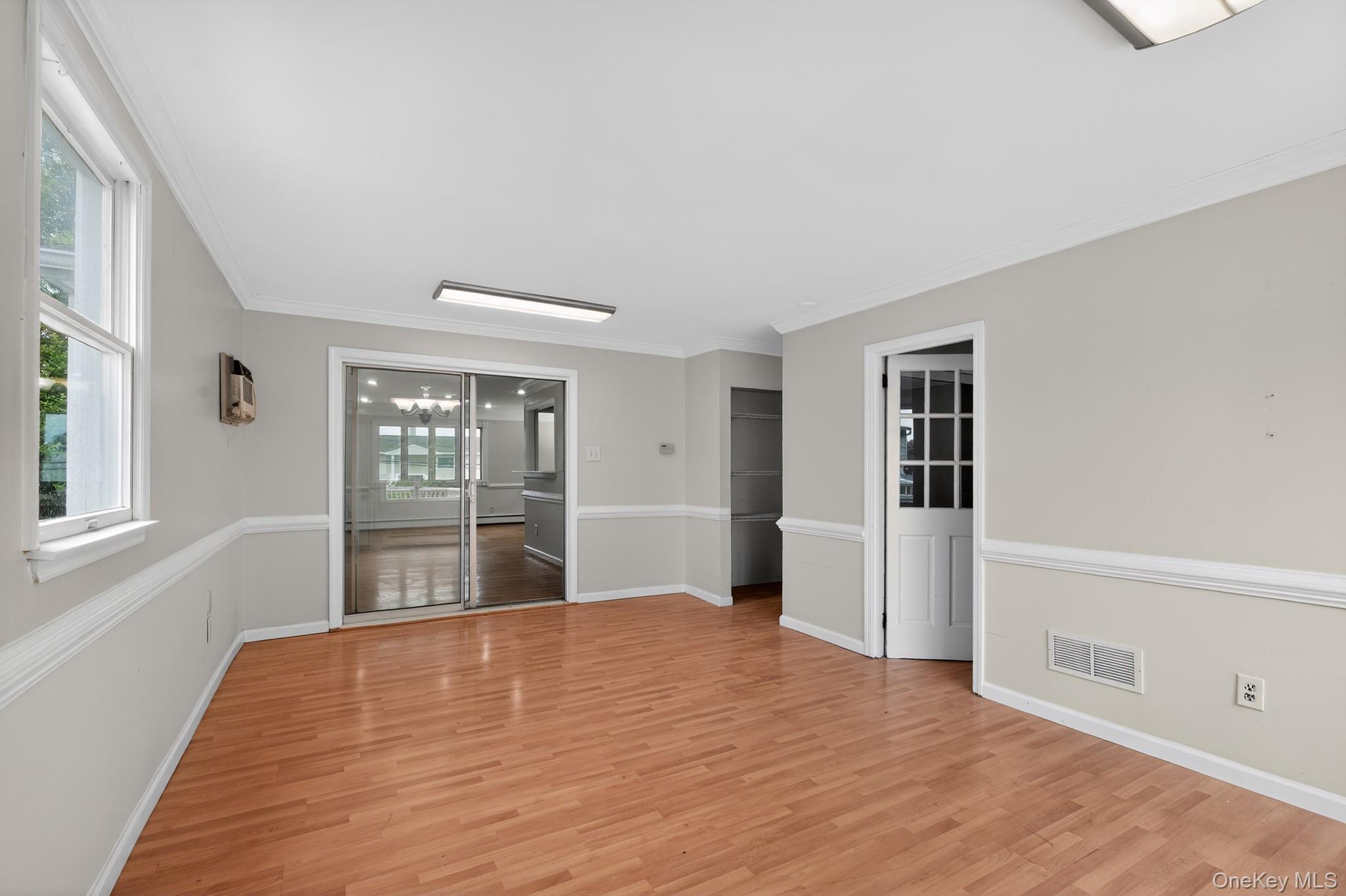 138 Spring Street Massapequa, NY 11758 - Photo 23 of 45 a view of an empty room with a window and wooden floor