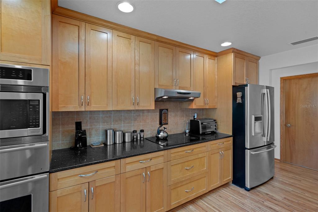 5035 Harbinger Road Spring Hill, FL 34608 - Photo 23 of 47 a kitchen with stainless steel appliances a refrigerator sink and cabinets