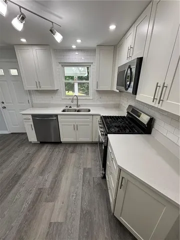 a kitchen with a sink and wooden floor